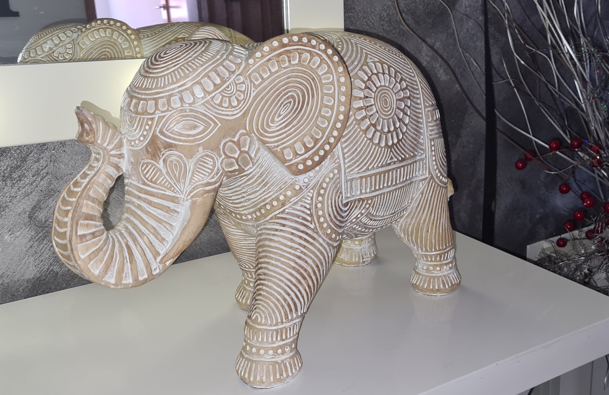 Figura decorativa de elefante tallado en tonos madera, expuesta en la tienda